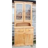 An early 20th century pine display bookcase with two glazed metal latticework doors