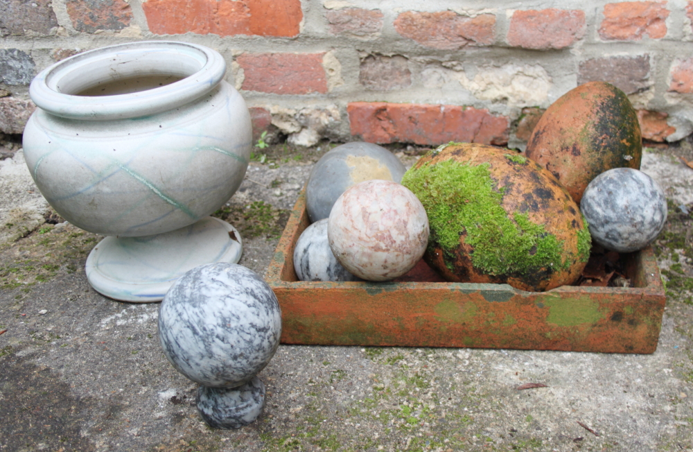 Four hardstone balls, a hardstone finial, two terracotta egg-shaped ornaments, a white glazed