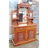 A mahogany sideboard with raised mirrored back over two short drawers and two carved panel doors, on