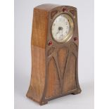 An Art Nouveau walnut and copper mounted mantel clock with three garnet coloured cabochons and