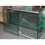 A glazed display cabinet with sliding doors, 31" wide x 10" deep x 22" high with metal wall brackets
