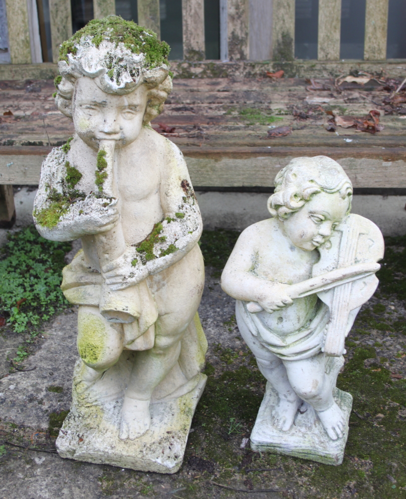 A sandstone figure of a boy playing a horn, 28" high, and a similar figure of a boy playing a violin