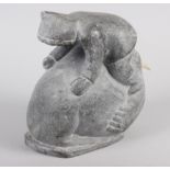 An Inuit hardstone model of a man on a walrus, 8" high (damaged)