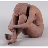 A stoneware sculpture of a crouching nude figure, 11" high