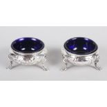 A pair of Victorian salt cellars with embossed decoration, on three cabriole supports, 2.8oz troy