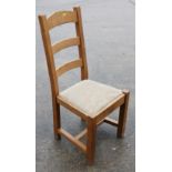 A set of six French oak ladder back dining chairs with padded seats, on square stretchered supports