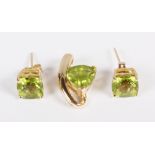 A peridot pendant and matching studs mounted in yellow metal, stamped 14k/585