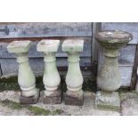 Three cast stone turned columns, on square bases, 18 3/4" high, and another similar, 21" high