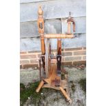 A late 19th century fruitwood spinning wheel, 35" high, a late 19th century carved oak circular to