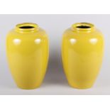 A pair of yellow enamel oviform vases, 8" high (chips to necks)