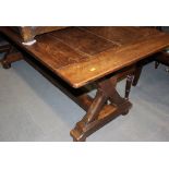 An Arts & Crafts style oak refectory table with plated planked top, on 'X' frame chamfered