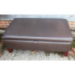 A box seat ottoman, upholstered in a chocolate leather, on square taper supports, 40" wide x 24"