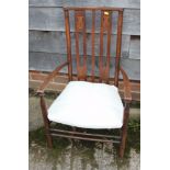 An Arts & Crafts polished as walnut low armchair with slatted back and white floral fabric seat