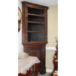 A Victorian 17th century design carved oak corner cupboard with open shelves over single door, on