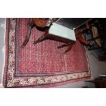 A Caucasian rug with small elephant gull designs and multi-borders on a red ground in shades of