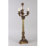 A 19th century brass four-light table candelabra with rams heads on triform base (now converted to