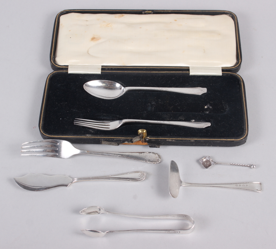 A silver part christening set (missing knife), a baby's food pusher, a fork, a pair of sugar