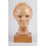 A 1930s terracotta portrait bust of a woman with a long plait, 13" high