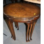 A nest of three oval figured walnut occasional tables, on cabriole supports, 22" wide max
