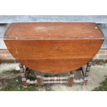 An oak oval top gateleg table, on bobbin turned and stretchered supports, 36" wide x 46" deep x 27"