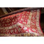 A Kashmir all-over floral patterned rug in shades of natural and blue on a red ground, 94 1/2" x 63"