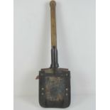 A WWII German Infantry issue early pattern solid type trenching tool, with leather cover.
