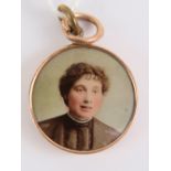 A vintage rose metal pendant having enamelled female portrait within, 22mm dia.