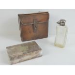 A vintage pigs skin leather hunting pouch containing a silver plated cake tin and flask,