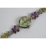 A silver and gemstone ladies wristwatch having mother of pearl dial, strap set with amethyst,