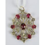 A delightful late Victorian seed pearl and red stone pendant of floral form (one seed pearl