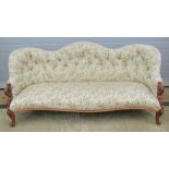 A Victorian settee having shaped front and button back, carved and pierced supports to each side.