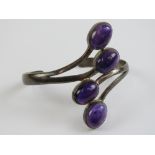 A silver and amethyst bangle having four large oval cabachons approx 15 x 11mm each, hallmarked 925.