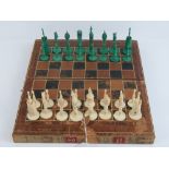 A 19th century ivory and dyed chess set of stylised pieces (queen chess piece a/f),