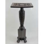 An unusual square shaped blind carved side table having carved stem with square base over four