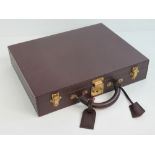 A burgundy leather covered Louis Vuitton briefcase bearing LV to the locks,