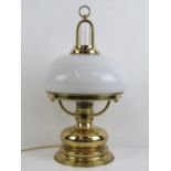 A table lamp in the style of a Victorian oil lamp with milk glass shade, wired for electricity.