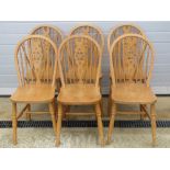 A set of six contemporary beechwood wheel back dining chairs.