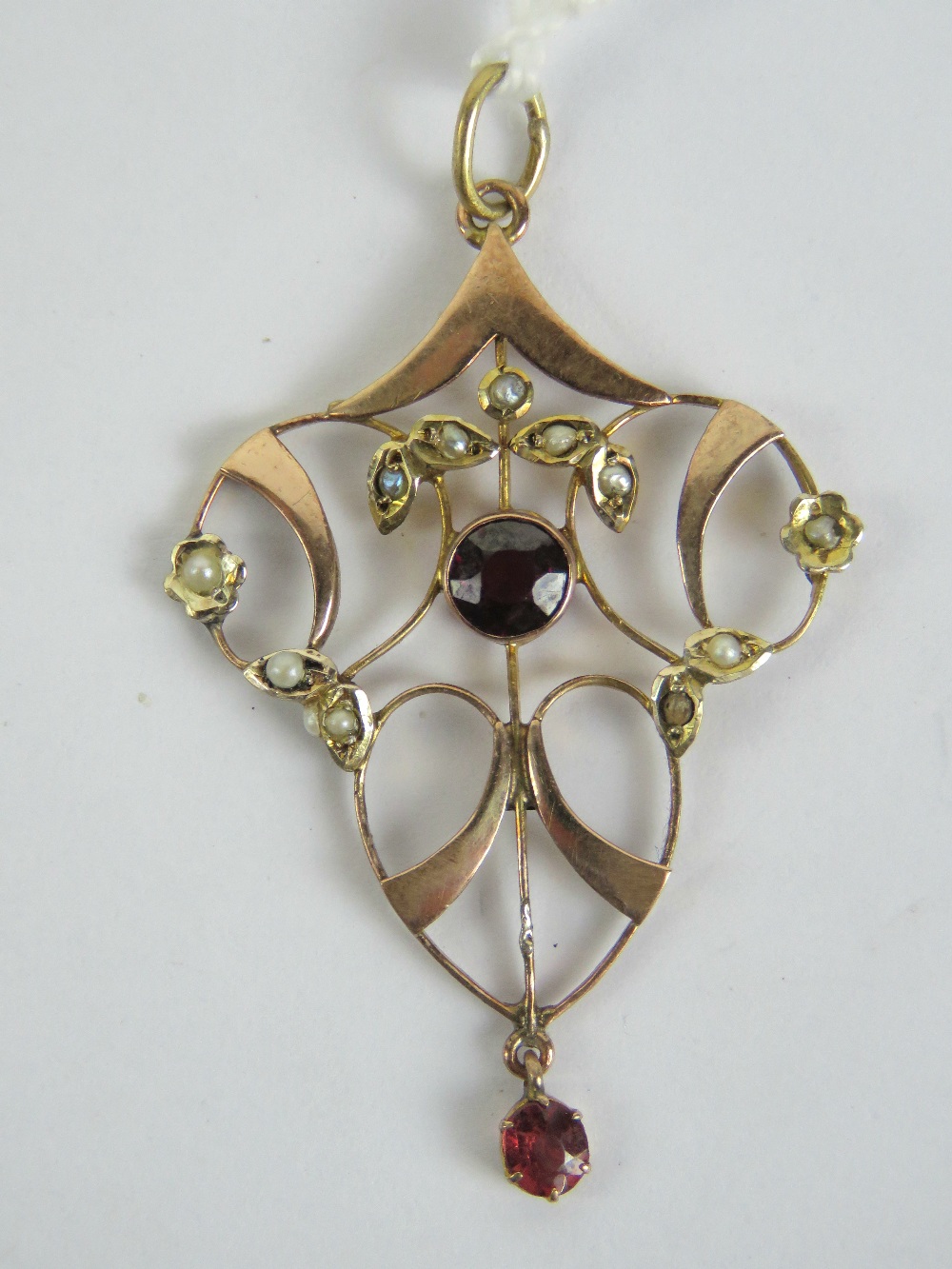 A delightful 9ct gold Edwardian garnet and seed pearl pendant of floral form, stamped 9ct, 4.