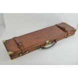 A fine leather 12 gauge shotgun case having brass corner bracing and lock,