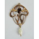 A delightful 9ct gold art nouveau pendant having large central oval cut garnet,