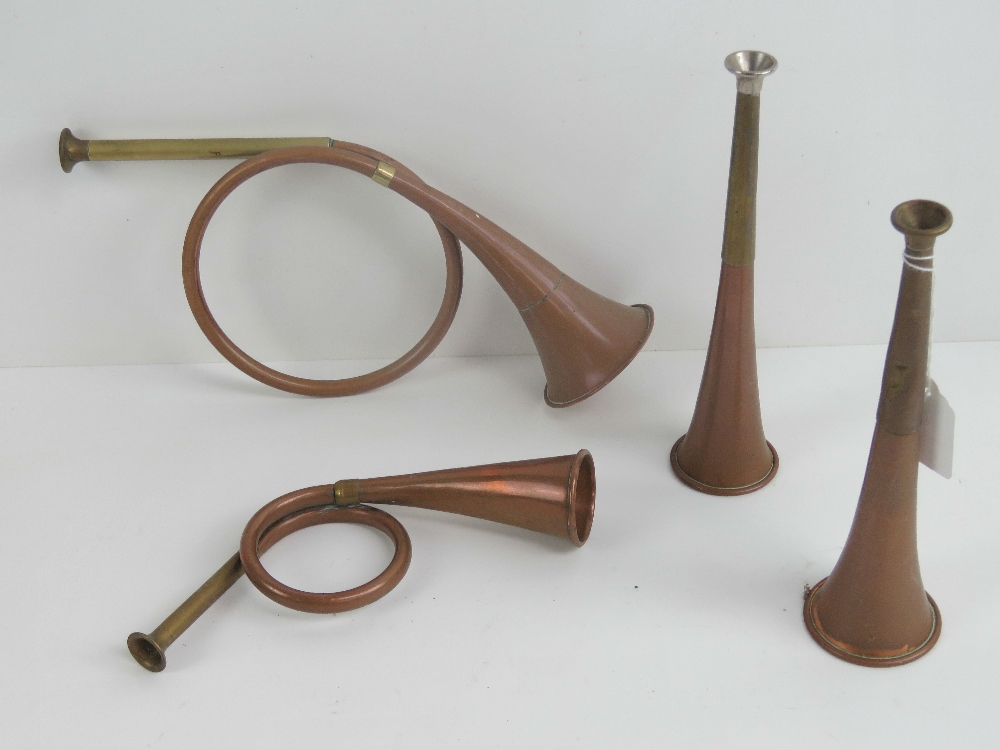 Four 20th Century hunting horns, two straight, two coiled.