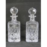 A pair of square shaped lead crystal decanters each with stopper and standing 27.5cm high.