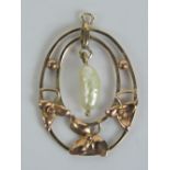 An Edwardian floral pendant having central pearl suspended over leaf design panels,