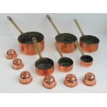 A contemporary set of six graduating copper and brass pans,