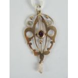 A 9ct gold art nouveau pendant having central oval cut garnet, pearl suspended below,