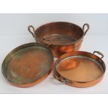 Three assorted shallow copper pans each with side handles and measuring 29cm,