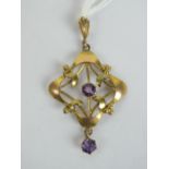 An Edwardian 9ct gold pendant having two round cut amethysts upon floral frame, stamped 9ct, 4.