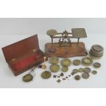 A set of postal balance scales raised over shaped mahogany base,