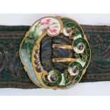 A floral enamelled belt buckle having cut steel cabachons upon and having fabric belt.