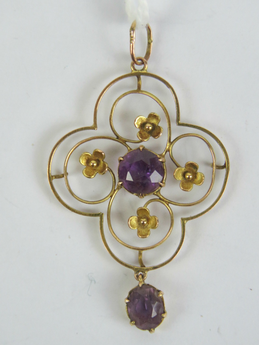 A delightful Edwardian pendant having floral scroll work pattern with central round cut amethyst